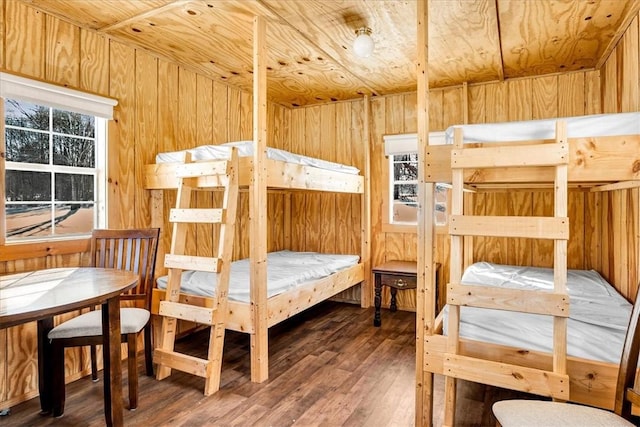 bedroom with wood ceiling, multiple windows, wood finished floors, and wood walls