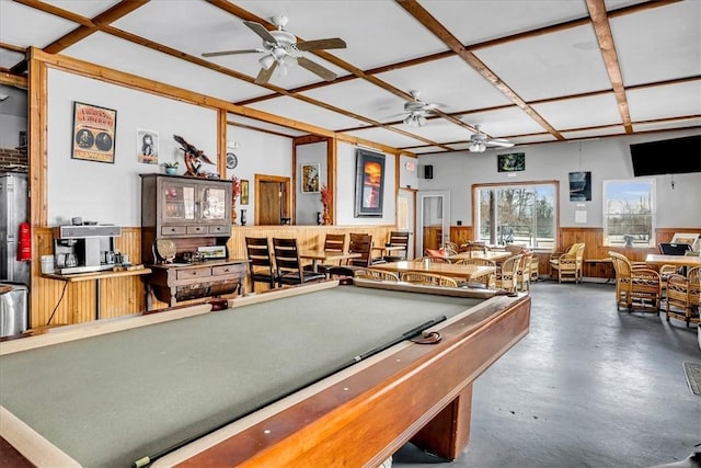 game room featuring coffered ceiling, ceiling fan, wainscoting, and finished concrete flooring