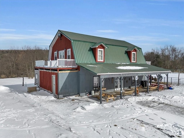 exterior space with a gambrel roof and metal roof