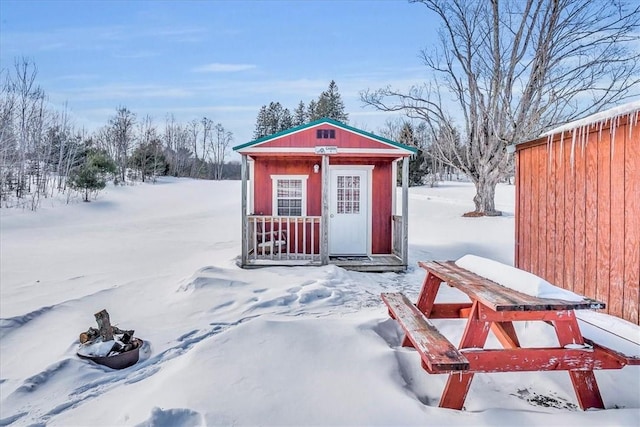 snow covered structure featuring an outdoor structure