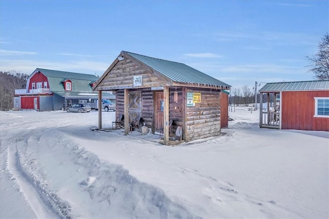 snow covered structure featuring an outdoor structure