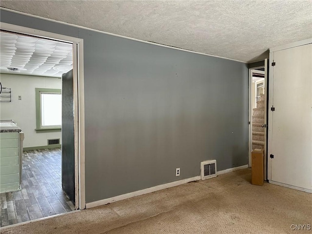 unfurnished room with visible vents, baseboards, and a textured ceiling