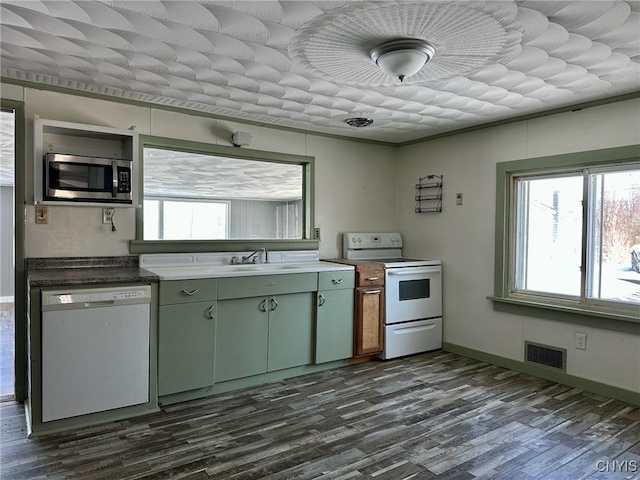 kitchen featuring visible vents, a healthy amount of sunlight, green cabinets, dark wood-style floors, and white appliances