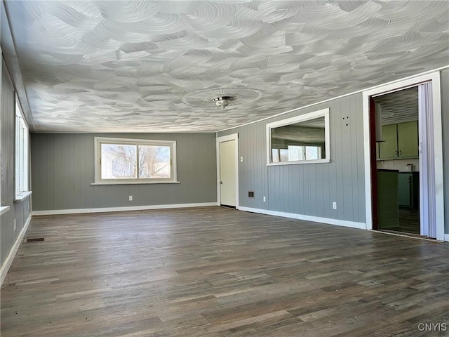 empty room featuring dark wood finished floors and baseboards