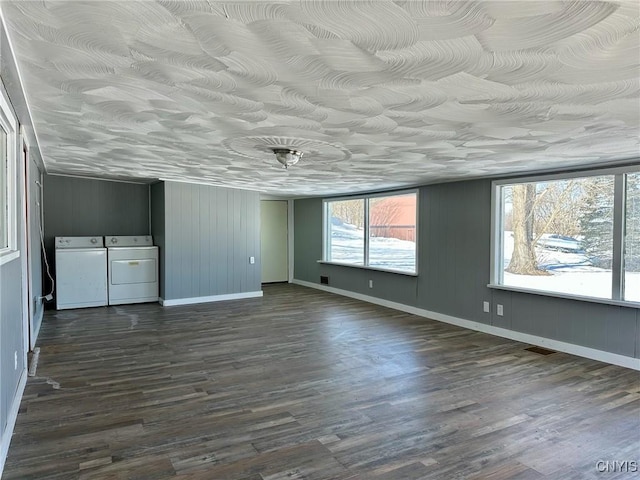 unfurnished bedroom featuring dark wood finished floors, visible vents, baseboards, and washing machine and clothes dryer