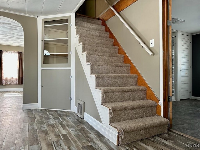 stairs featuring visible vents, baseboards, and wood finished floors