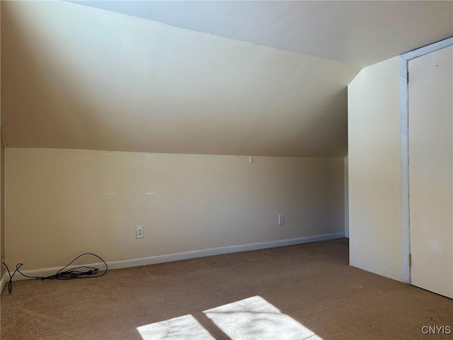 bonus room with lofted ceiling and carpet flooring