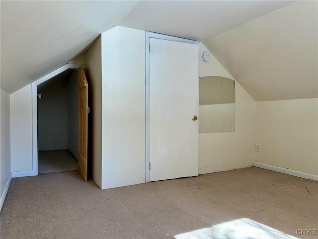 additional living space featuring carpet flooring and vaulted ceiling