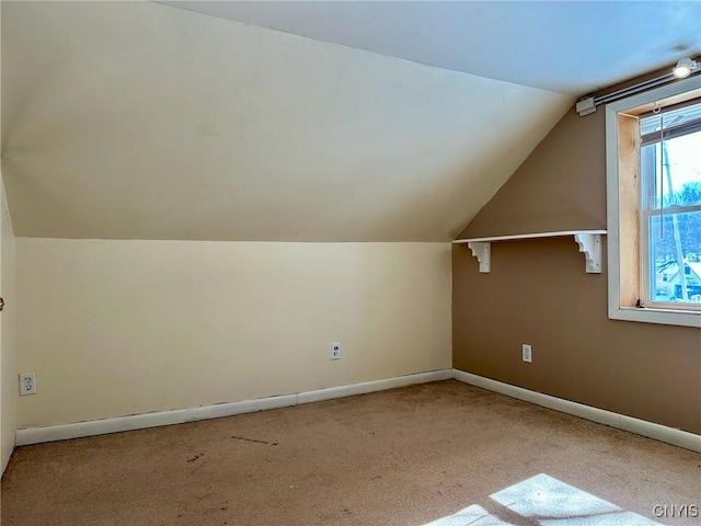 additional living space featuring baseboards, carpet flooring, and vaulted ceiling