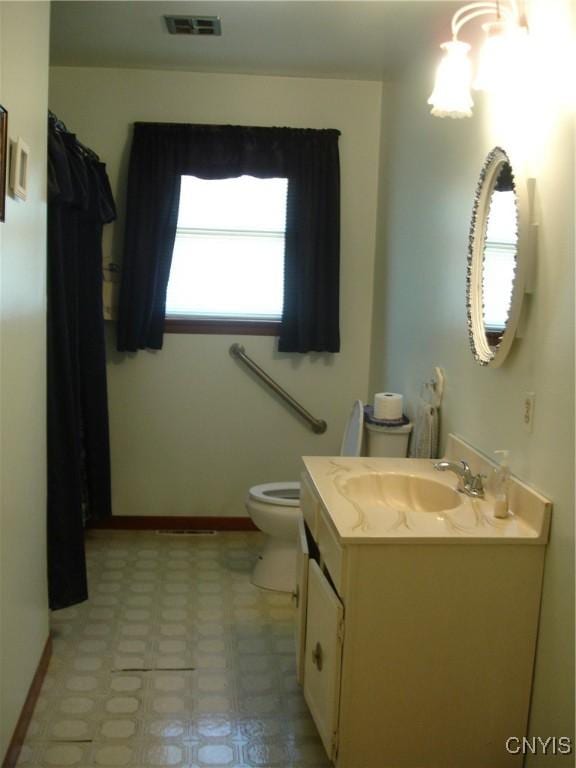 full bath with vanity, baseboards, visible vents, tile patterned floors, and toilet