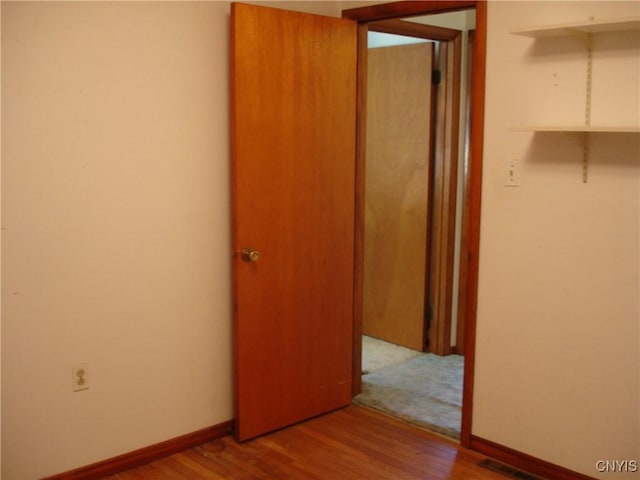 interior space with visible vents, baseboards, and wood finished floors