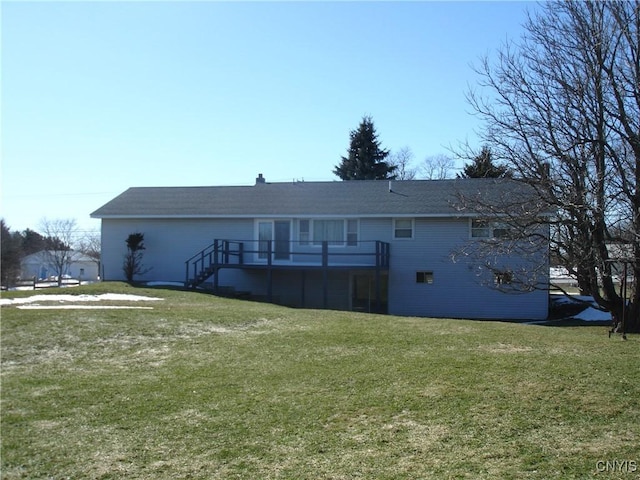 back of property featuring a deck, a yard, and stairs