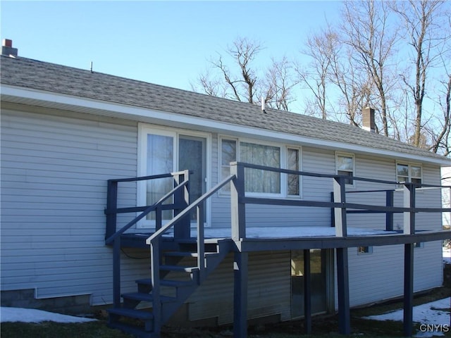 exterior space with a chimney and a shingled roof