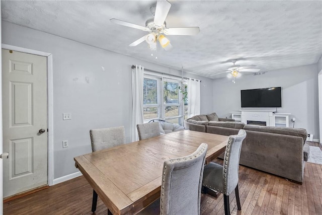 dining space featuring baseboards, a textured ceiling, a ceiling fan, and hardwood / wood-style flooring