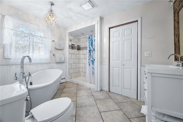 bathroom featuring tile patterned flooring, a shower stall, a freestanding bath, toilet, and a baseboard radiator