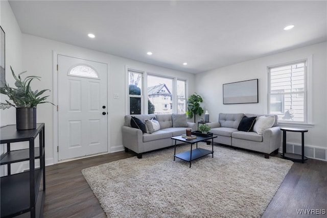 living area with dark wood-type flooring, recessed lighting, visible vents, and baseboards