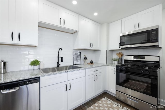 kitchen featuring a sink, dark wood-style floors, appliances with stainless steel finishes, and white cabinets