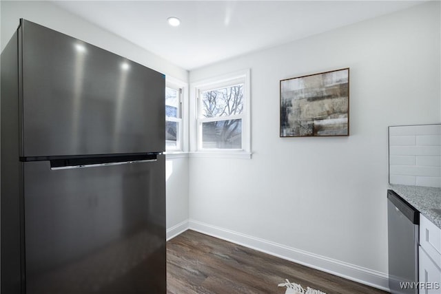 kitchen with light stone countertops, baseboards, recessed lighting, dark wood-type flooring, and appliances with stainless steel finishes