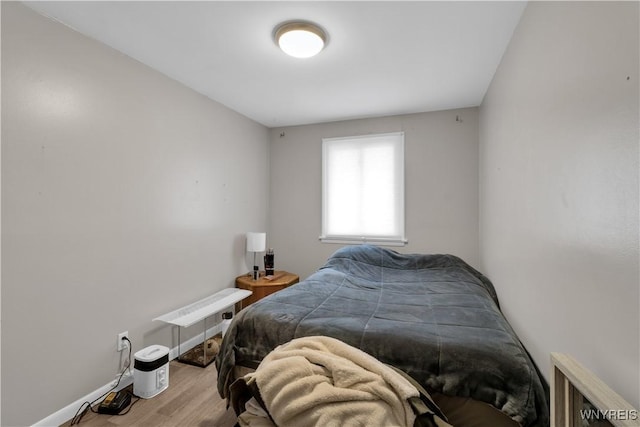 bedroom featuring baseboards and wood finished floors