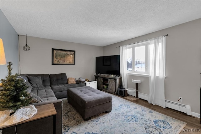 living area featuring a baseboard radiator, wood finished floors, baseboards, and a textured ceiling