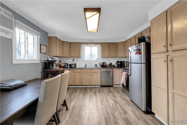 kitchen with light brown cabinetry, appliances with stainless steel finishes, light wood-type flooring, and a sink