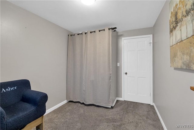 sitting room featuring carpet flooring and baseboards