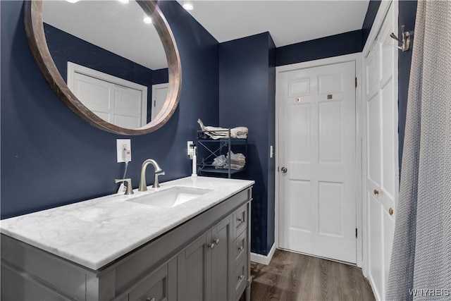 bathroom featuring baseboards, wood finished floors, and vanity