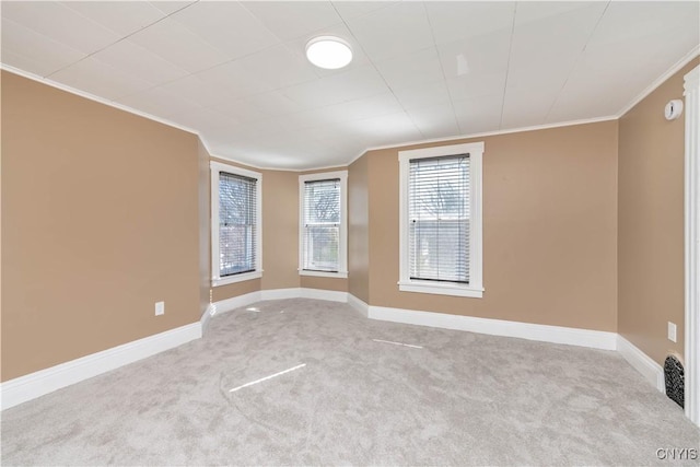 carpeted spare room featuring baseboards and ornamental molding