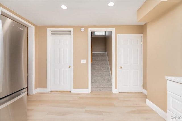 unfurnished bedroom with recessed lighting, baseboards, light wood-style flooring, and freestanding refrigerator