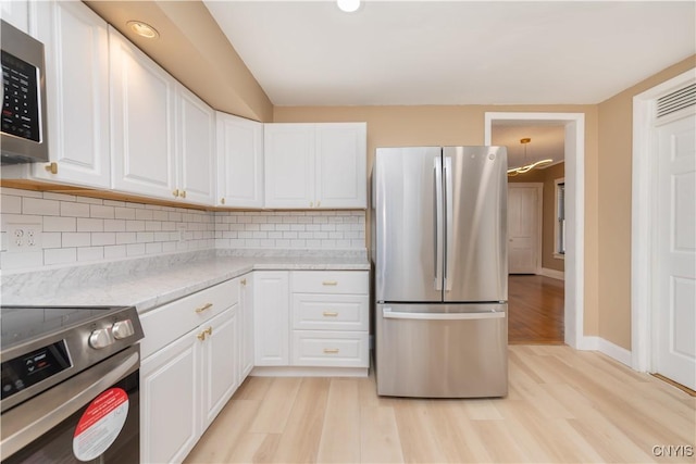 kitchen with stainless steel appliances, white cabinets, and decorative backsplash