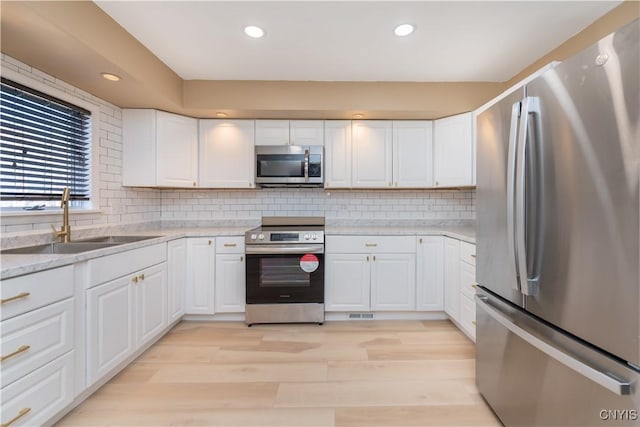 kitchen featuring a sink, appliances with stainless steel finishes, and white cabinetry