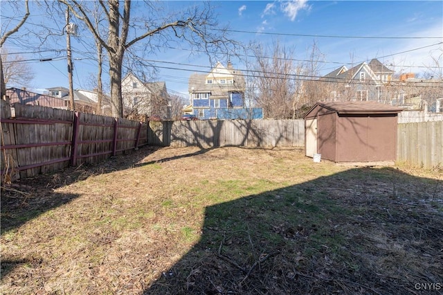 view of yard featuring an outbuilding, a storage unit, and a fenced backyard