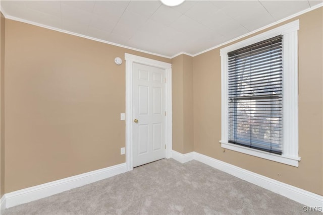 unfurnished room with baseboards, carpet, and crown molding