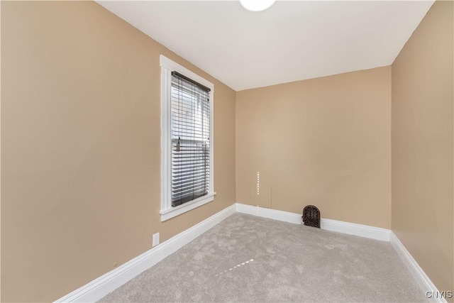 spare room featuring carpet and baseboards