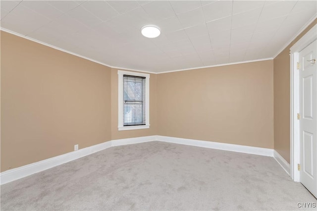 carpeted spare room featuring baseboards and ornamental molding