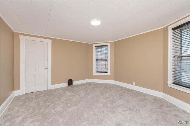 spare room with carpet flooring, baseboards, and ornamental molding