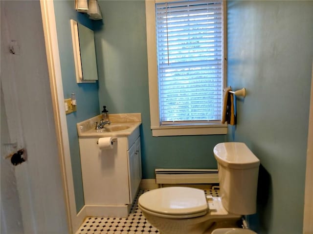 bathroom with a baseboard heating unit, baseboards, toilet, and vanity