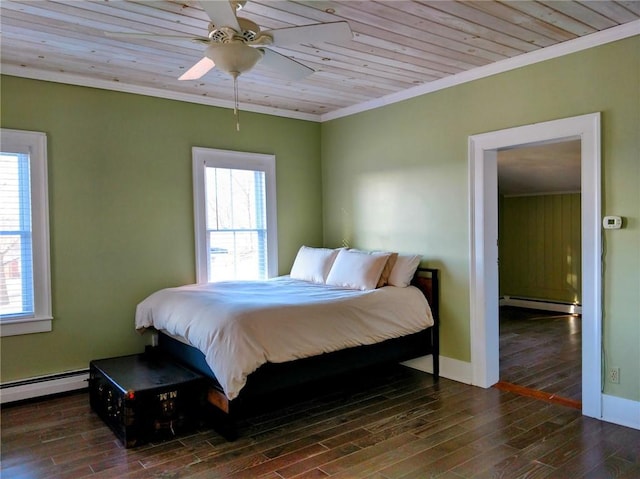 bedroom featuring a baseboard heating unit, wood finished floors, and ornamental molding