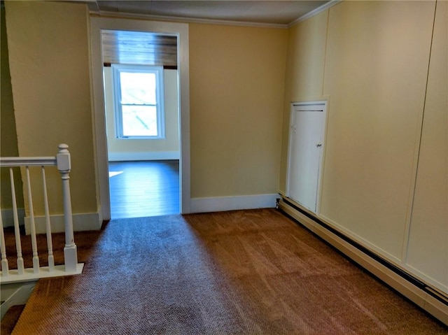 carpeted spare room featuring a baseboard heating unit, baseboards, and ornamental molding