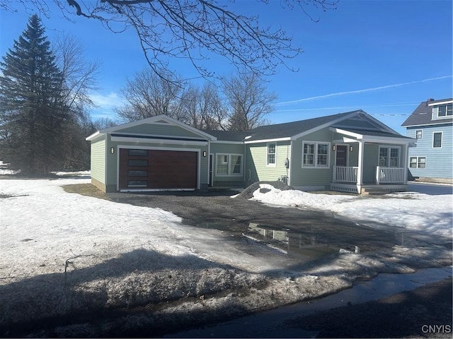 view of front of home with covered porch, driveway, and a garage