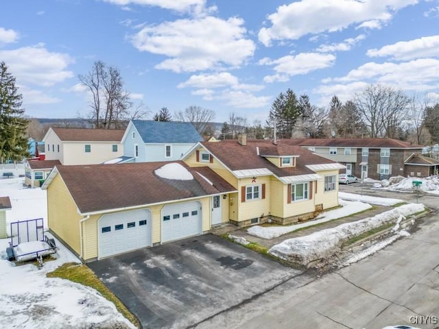 view of front facade with aphalt driveway, an attached garage, and a residential view