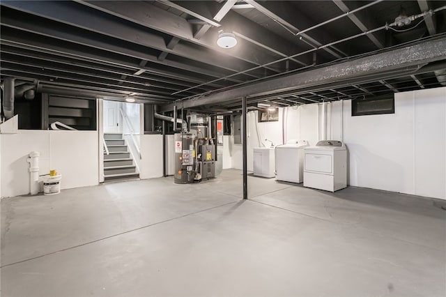 unfinished basement featuring washer and dryer, stairway, electric panel, and water heater