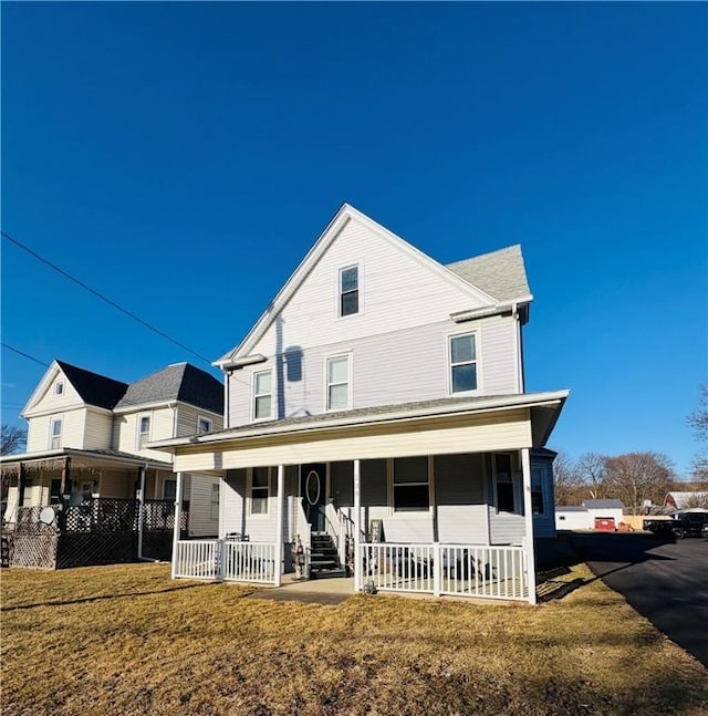 view of front of property with covered porch and a front lawn