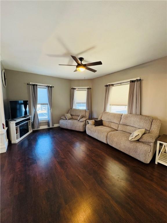 unfurnished living room featuring baseboards, ceiling fan, and wood finished floors