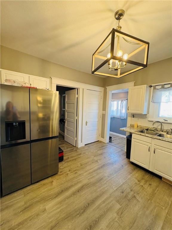 kitchen with a sink, plenty of natural light, stainless steel fridge with ice dispenser, and white cabinetry