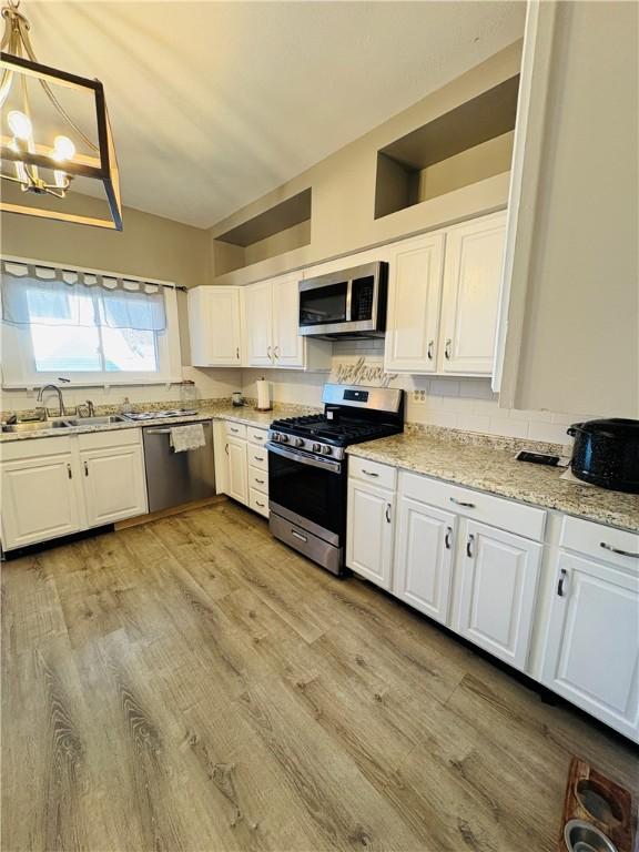 kitchen featuring white cabinetry, light wood-style floors, and stainless steel appliances