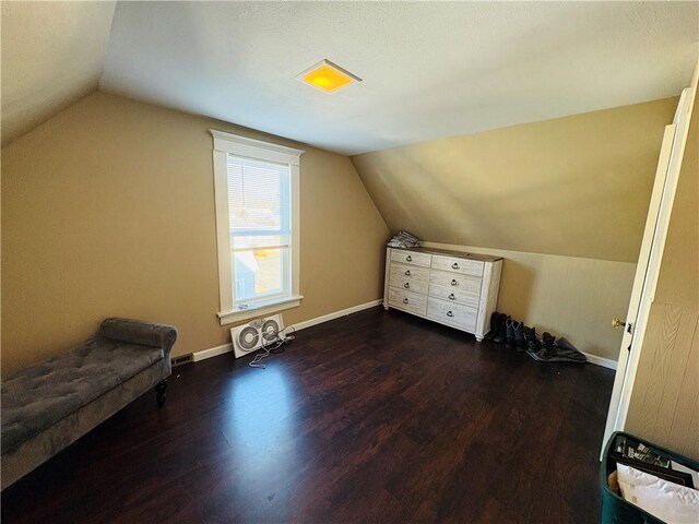 additional living space featuring vaulted ceiling, baseboards, and dark wood-style flooring