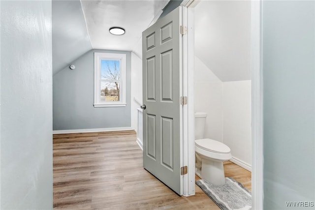 bathroom featuring vaulted ceiling, toilet, wood finished floors, and baseboards