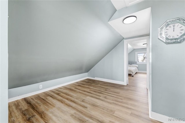 bonus room featuring baseboards, wood finished floors, and vaulted ceiling