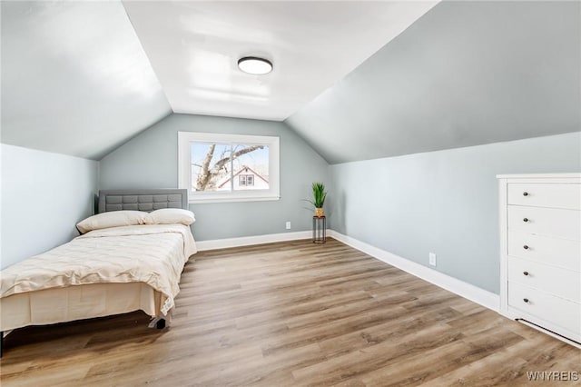 bedroom featuring vaulted ceiling, wood finished floors, and baseboards